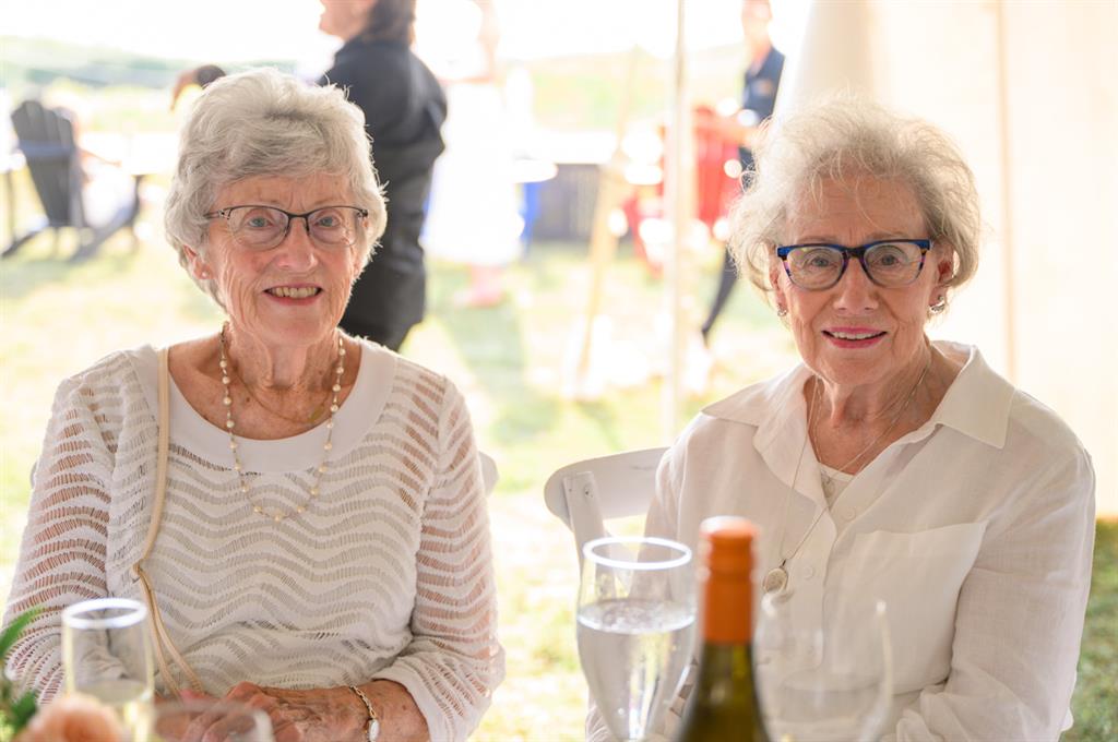 two women seated at long table dinner